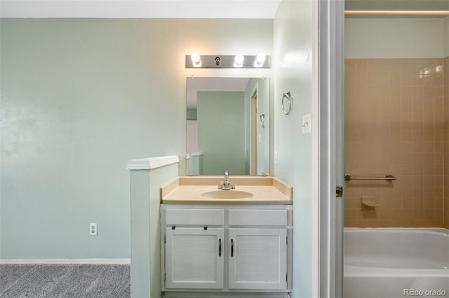 bathroom featuring tiled shower / bath and vanity