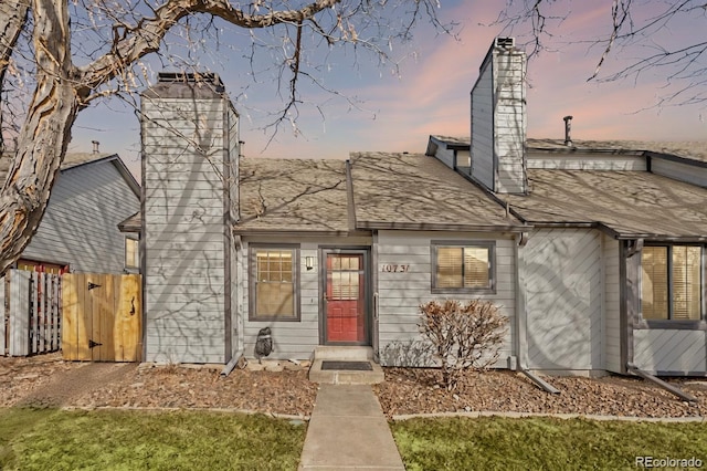 view of front of home featuring fence and a chimney