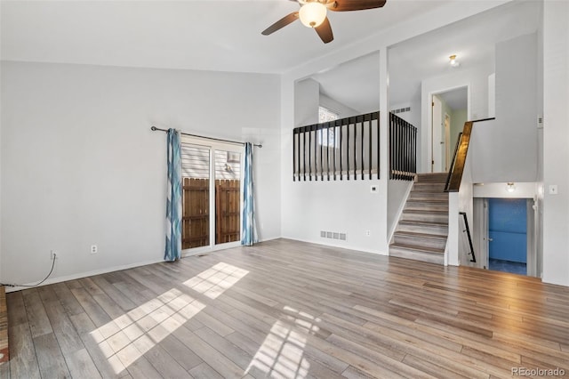 10731 W 63rd Ave Unit A, Arvada, CO 80004 - unfurnished living room with a ceiling fan, wood finished floors, stairs, baseboards, and high vaulted ceiling