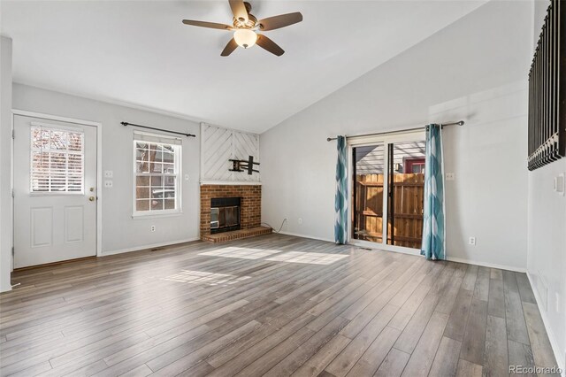 10731 W 63rd Ave Unit A, Arvada, CO 80004 - unfurnished living room with a ceiling fan, wood finished floors, a fireplace, baseboards, and high vaulted ceiling