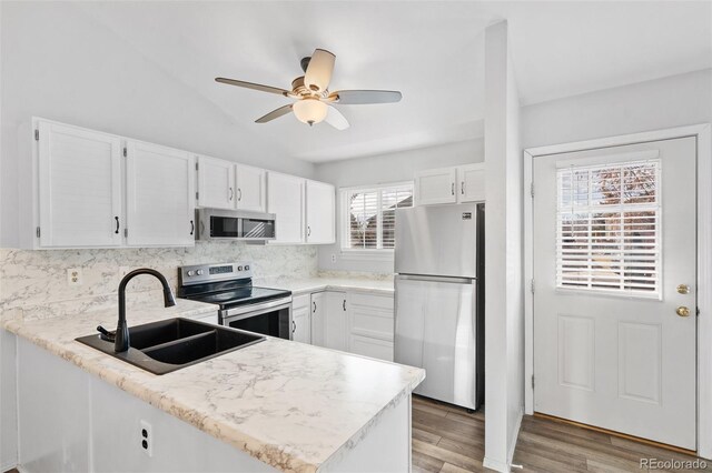 10731 W 63rd Ave Unit A, Arvada, CO 80004 - kitchen featuring stainless steel appliances, a sink, a peninsula, white cabinetry, and a ceiling fan