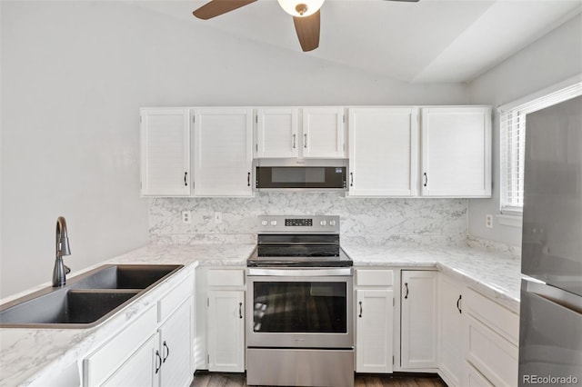 kitchen with a sink, white cabinets, appliances with stainless steel finishes, and vaulted ceiling