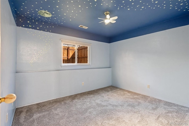 spare room with carpet flooring, a ceiling fan, and visible vents