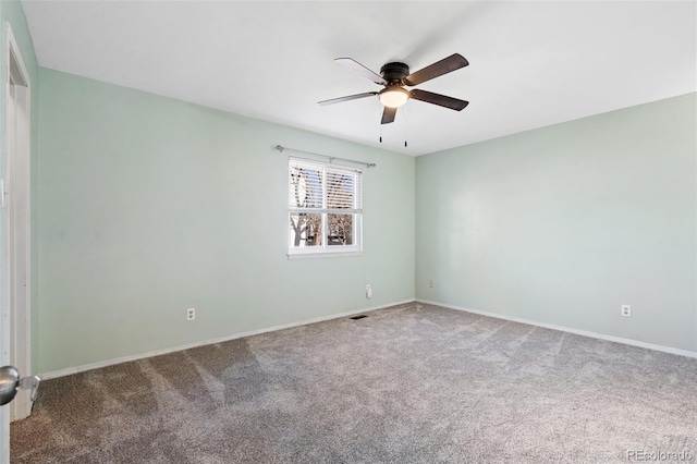 carpeted spare room with ceiling fan, visible vents, and baseboards