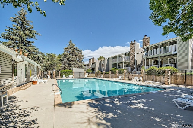 community pool featuring fence and a patio area
