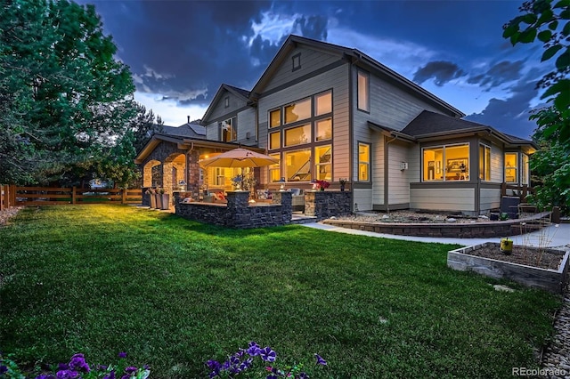 back house at dusk featuring a yard