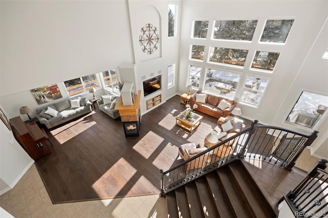 living room featuring a multi sided fireplace and a towering ceiling