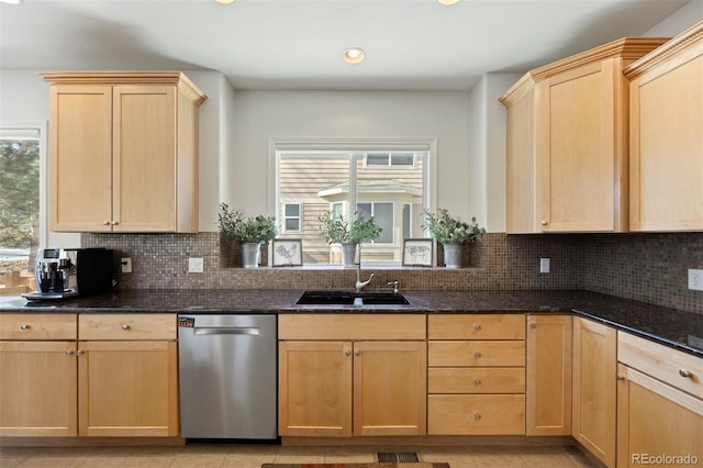 kitchen featuring tasteful backsplash, sink, dark stone countertops, stainless steel dishwasher, and light brown cabinets