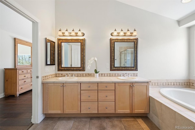 bathroom with vanity and tiled bath