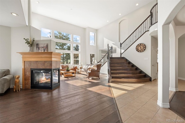 interior space with a high ceiling, a fireplace, and light hardwood / wood-style floors