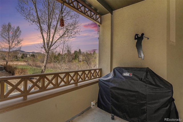 balcony at dusk featuring area for grilling