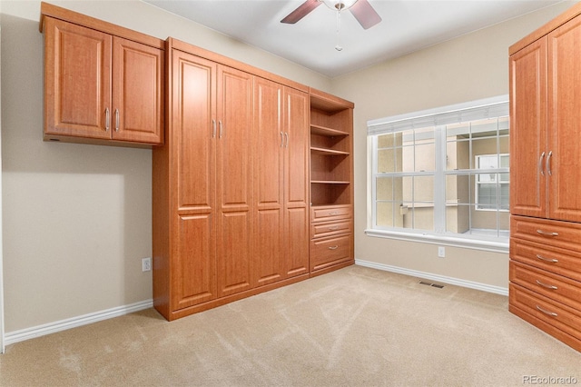 unfurnished bedroom featuring light colored carpet, a ceiling fan, baseboards, and visible vents