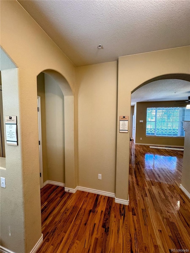 11962 W Long Cir Unit 103, Littleton, CO 80127 - hall with wood finished floors, arched walkways, and a textured ceiling