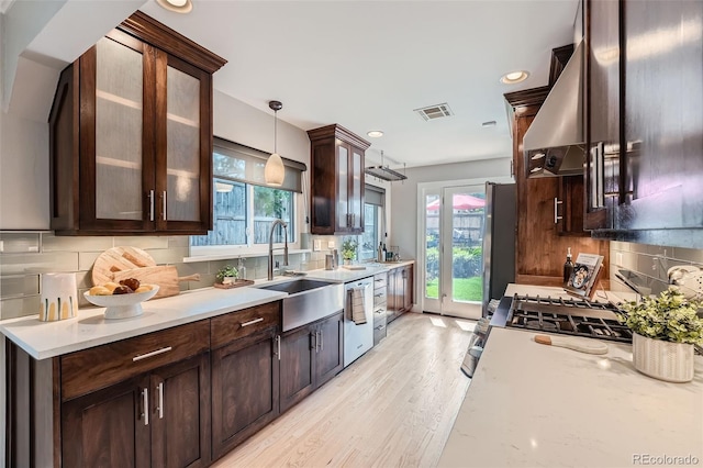 3530 E 8th Ave, Denver, CO 80206 - kitchen with dark brown cabinetry, plenty of natural light, backsplash, light wood-style flooring, and recessed lighting