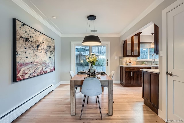 3530 E 8th Ave, Denver, CO 80206 - dining space with baseboard heating, healthy amount of natural light, light wood-type flooring, and crown molding