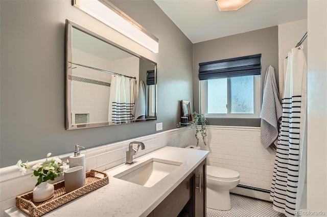 3530 E 8th Ave, Denver, CO 80206 - bathroom featuring baseboard heating, tile walls, vanity, tile patterned flooring, and a wainscoted wall