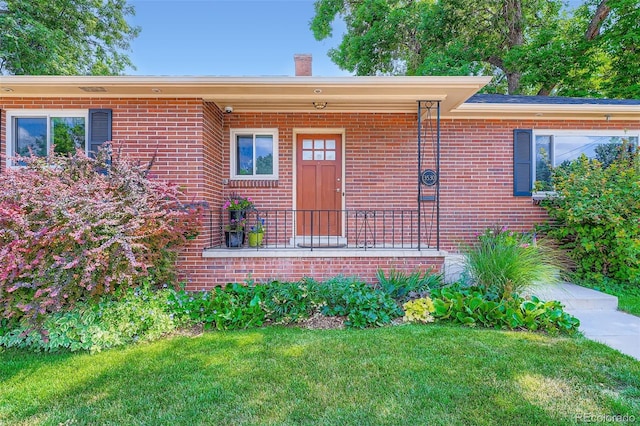3530 E 8th Ave, Denver, CO 80206 - property entrance featuring a chimney, brick siding, and a yard
