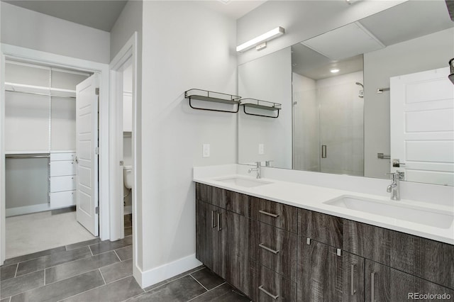 bathroom with tile patterned flooring, vanity, toilet, and an enclosed shower