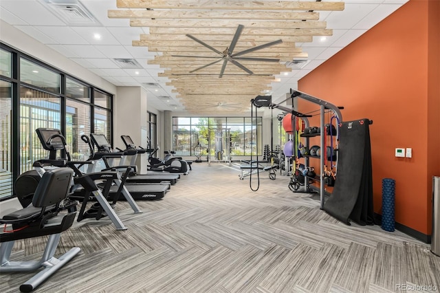 gym with carpet flooring, a paneled ceiling, and ceiling fan