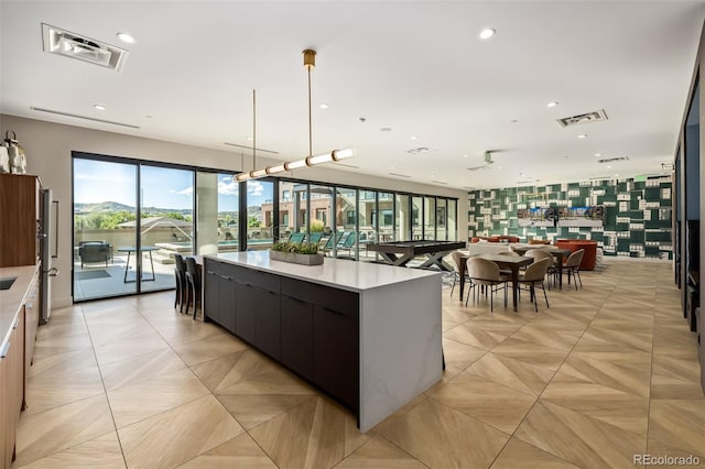 kitchen with pendant lighting, stainless steel refrigerator, and a large island