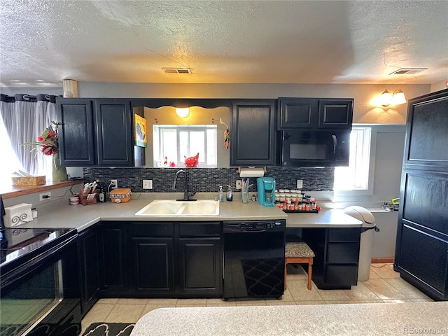 kitchen with light countertops, a textured ceiling, a sink, and black appliances