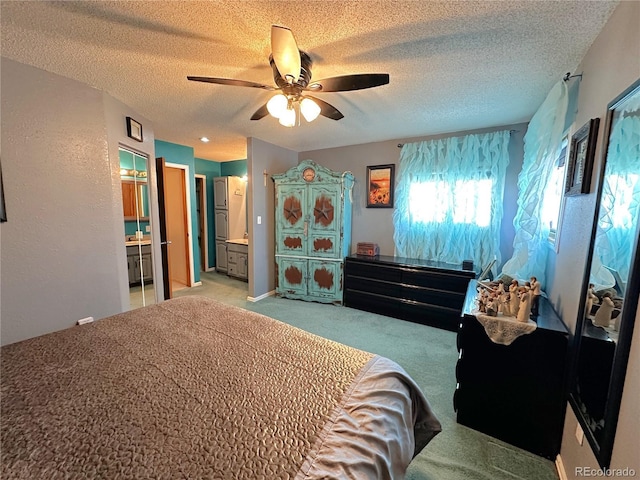 bedroom with connected bathroom, a textured ceiling, a ceiling fan, and light carpet