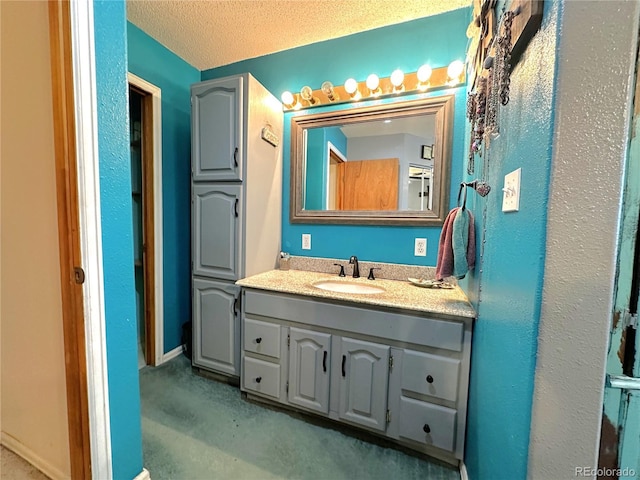 bathroom featuring a textured ceiling and vanity