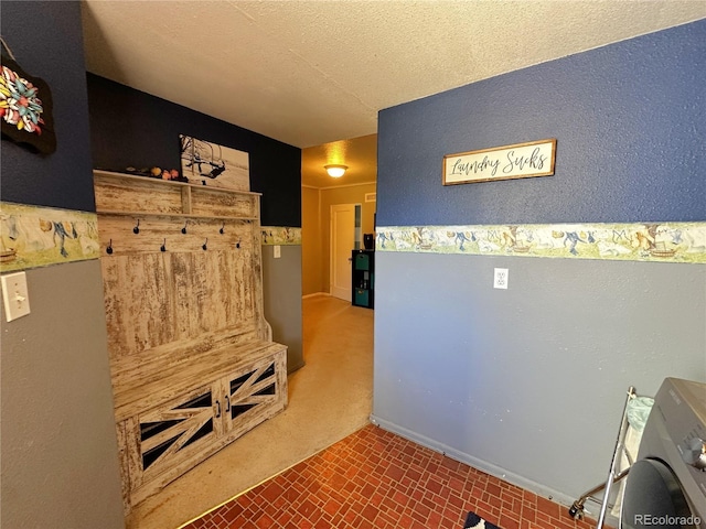 mudroom featuring a textured ceiling and washer / clothes dryer