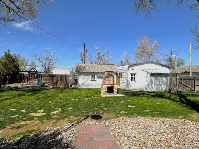 rear view of property with fence, a lawn, and a playground