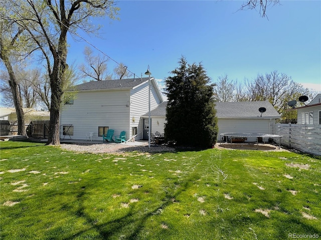 rear view of property with fence, a lawn, and a patio area