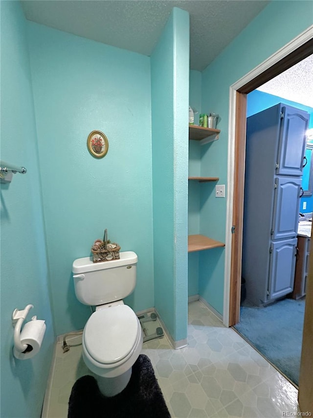 329 6th St, Hugo, CO 80821 - bathroom featuring toilet, tile patterned flooring, and a textured ceiling
