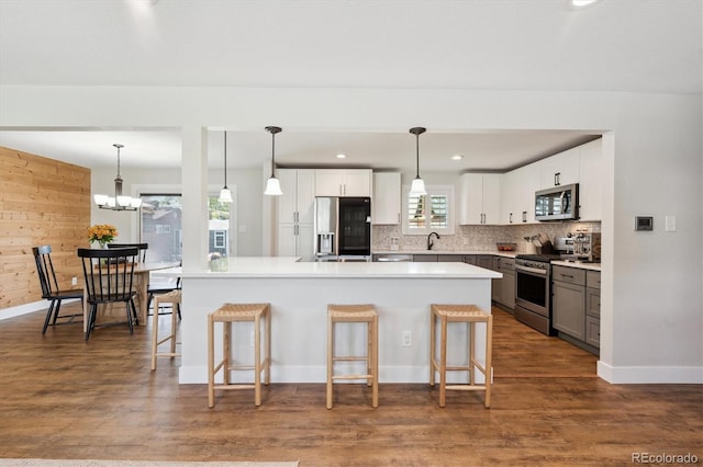 8242 E Briarwood Pl, Centennial, CO 80112 - kitchen with appliances with stainless steel finishes, a sink, a kitchen bar, baseboards, and backsplash