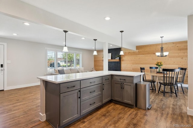 8242 E Briarwood Pl, Centennial, CO 80112 - kitchen featuring gray cabinets, wood walls, light countertops, hanging light fixtures, and a fireplace