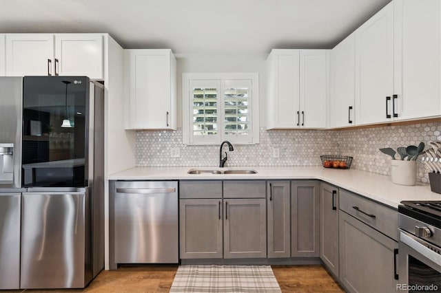 8242 E Briarwood Pl, Centennial, CO 80112 - kitchen featuring appliances with stainless steel finishes, a sink, light wood finished floors, and light countertops