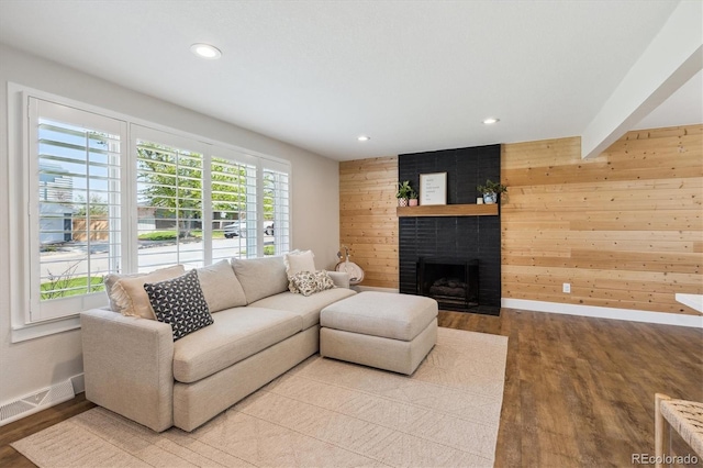 8242 E Briarwood Pl, Centennial, CO 80112 - living area featuring baseboards, wood finished floors, wood walls, a brick fireplace, and recessed lighting