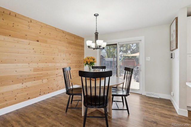 8242 E Briarwood Pl, Centennial, CO 80112 - dining area featuring a chandelier, dark wood-type flooring, baseboards, and wood walls