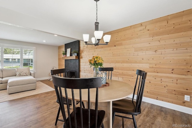 8242 E Briarwood Pl, Centennial, CO 80112 - dining area featuring baseboards, wood finished floors, a chandelier, wood walls, and recessed lighting
