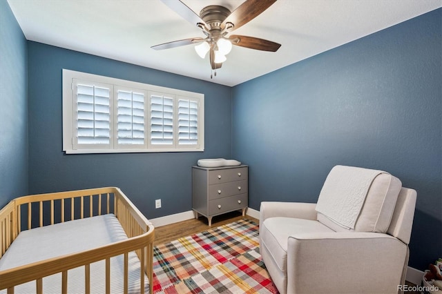 8242 E Briarwood Pl, Centennial, CO 80112 - bedroom featuring baseboards, wood finished floors, a nursery area, and ceiling fan