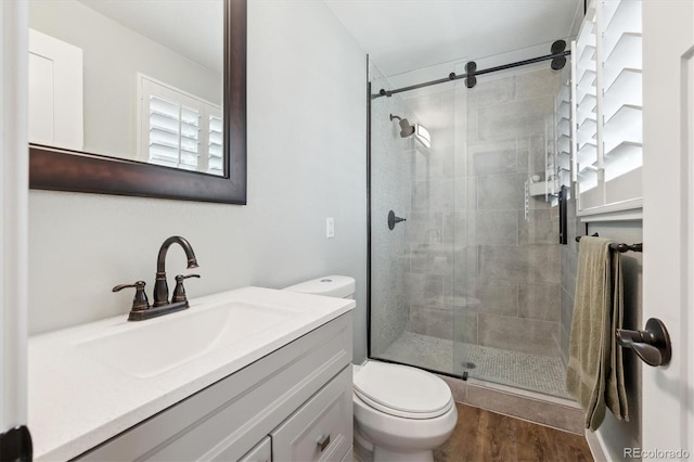 8242 E Briarwood Pl, Centennial, CO 80112 - bathroom with a stall shower, toilet, vanity, and wood finished floors