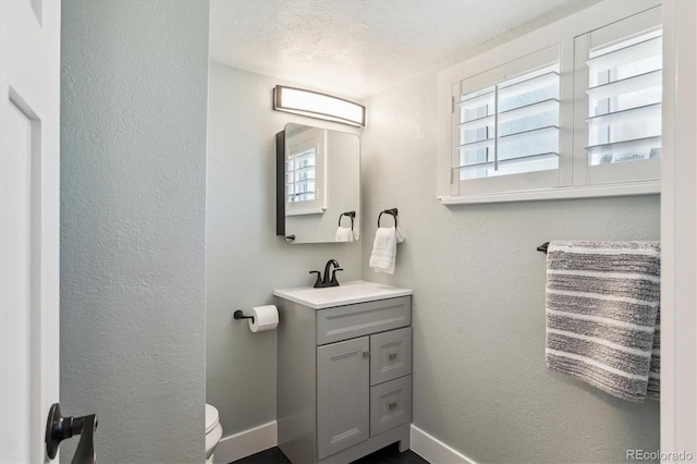8242 E Briarwood Pl, Centennial, CO 80112 - bathroom with baseboards, vanity, a textured wall, toilet, and a textured ceiling