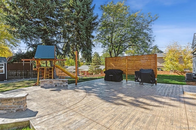 8242 E Briarwood Pl, Centennial, CO 80112 - view of patio featuring a playground, a fenced backyard, central AC unit, a shed, and an outdoor structure