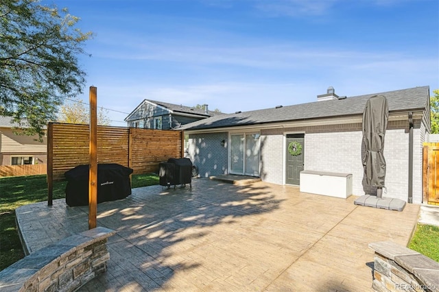 8242 E Briarwood Pl, Centennial, CO 80112 - rear view of house featuring brick siding, a fenced backyard, a patio area, and a shingled roof