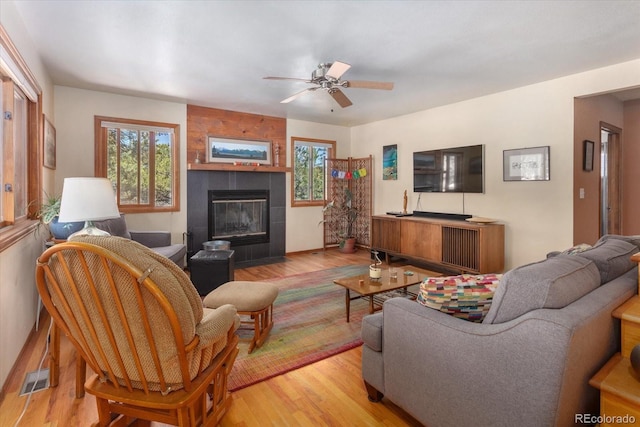 15700 County Road 352, Buena Vista, CO 81211 - living room featuring wood finished floors, a tiled fireplace, and ceiling fan