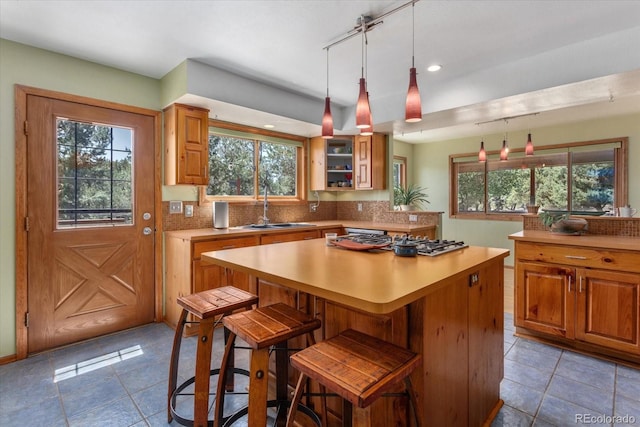 15700 County Road 352, Buena Vista, CO 81211 - kitchen with light tile patterned flooring, stainless steel gas stovetop, a kitchen island, light countertops, and decorative backsplash