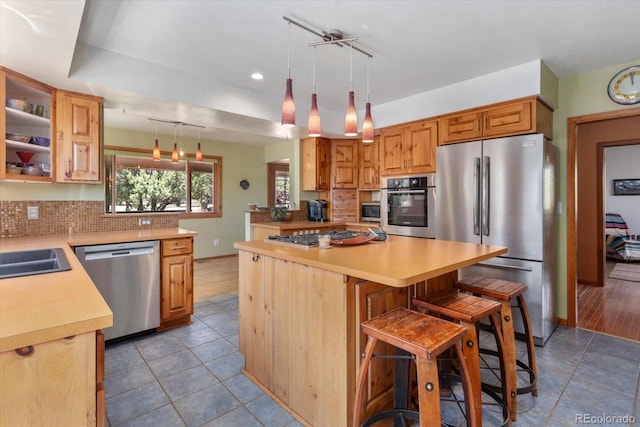 15700 County Road 352, Buena Vista, CO 81211 - kitchen with appliances with stainless steel finishes, decorative backsplash, light countertops, a kitchen bar, and light tile patterned floors