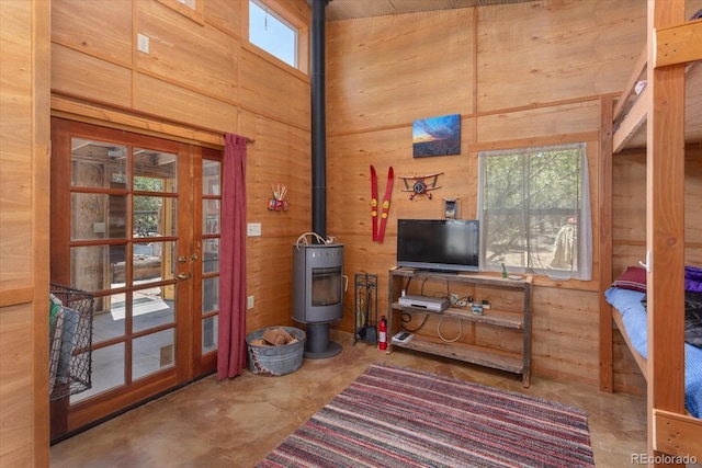 15700 County Road 352, Buena Vista, CO 81211 - living area featuring wood walls, concrete flooring, a wood stove, french doors, and a high ceiling