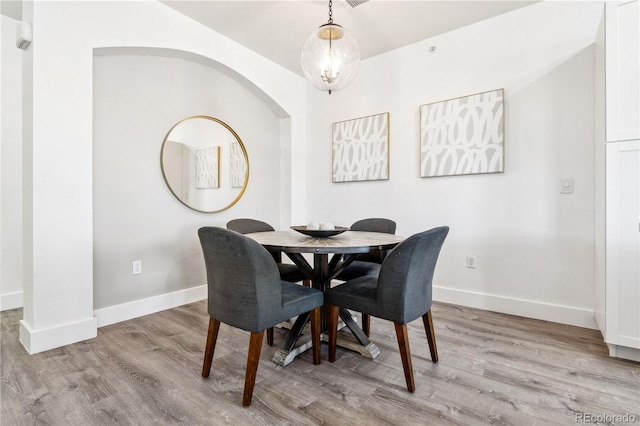 dining space featuring a notable chandelier and light wood-type flooring