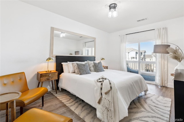 bedroom featuring access to exterior and wood-type flooring