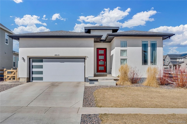 prairie-style house featuring stucco siding, driveway, and a garage