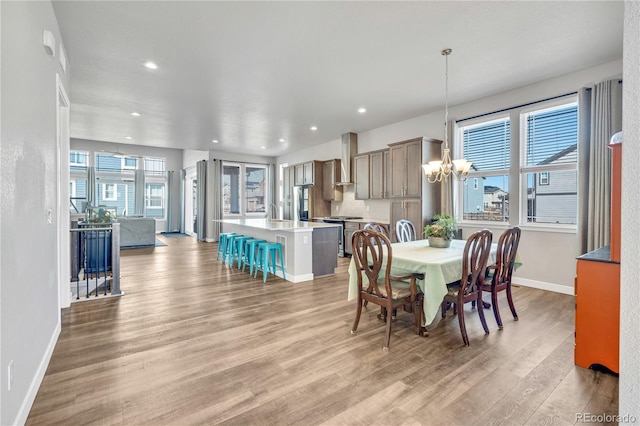 dining area with baseboards, recessed lighting, a chandelier, and light wood-type flooring